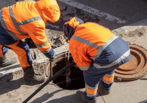Workers inspecting roadside drainage system